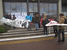 group of protesters with banners calling for boycott of the event