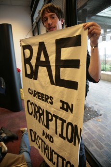 Student holding banner reading "BAE: Careers in corruption and destruction"